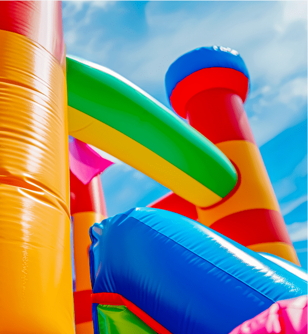 Colorful inflatable bounce house with slides under a blue sky